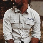 a man wearing a tan shirt, reading MAINE on it